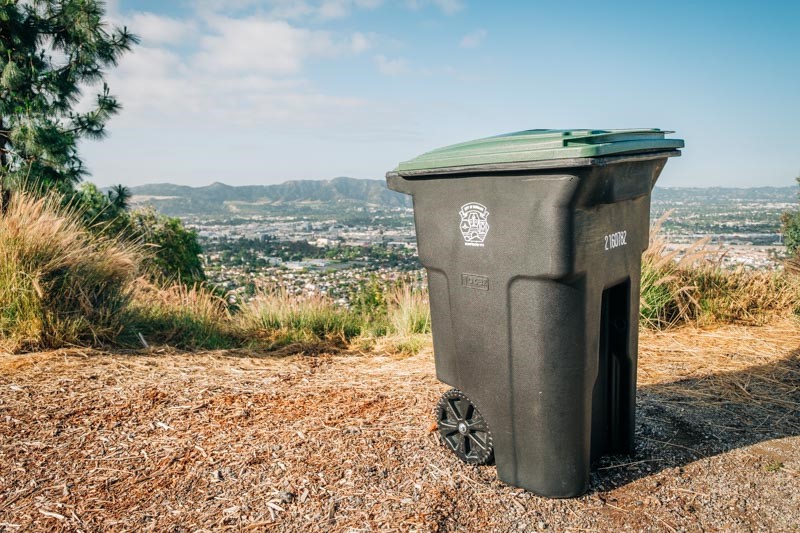 A lone organics bin forlornly standing on a hilltop, the City of Burbank visible in the background.